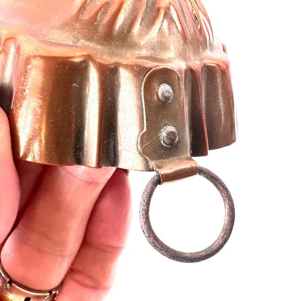 Copper mold hanging ring and fluted base detail showing metal attachment and craftsmanship