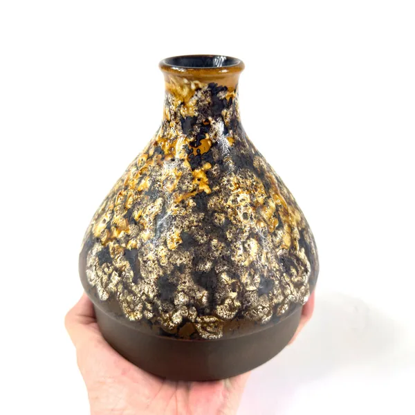 Cradled vase showing even glaze coverage across bulbous body with cream and mustard pooling
