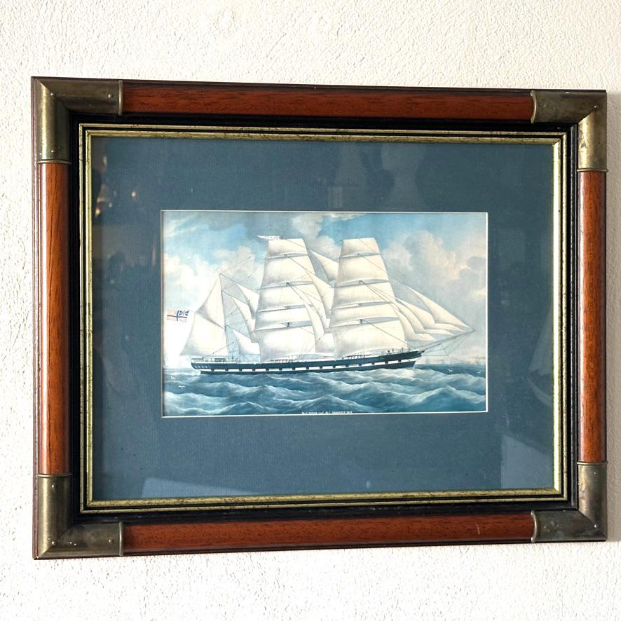 Direct view of wooden frame with brass corner fittings holding barque VENUS maritime print behind glass and blue mount