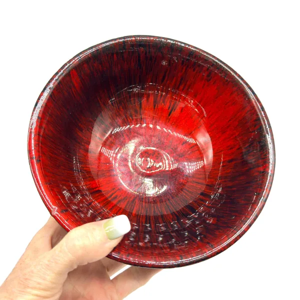 Ernst red pottery bowl held in hand, showing scale, glossy interior glaze, and depth of form, palm-sized piece