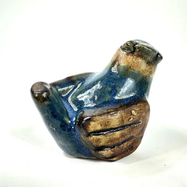 Fischer stoneware bird figurine at three-quarter angle, displaying full glaze contrast between navy body and warm wing tones