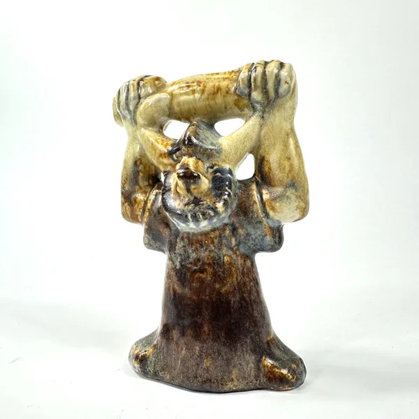 Full front view of ceramic Viking figure displaying symmetrical raised arms, pale cream glaze on shoulders, aged brown base