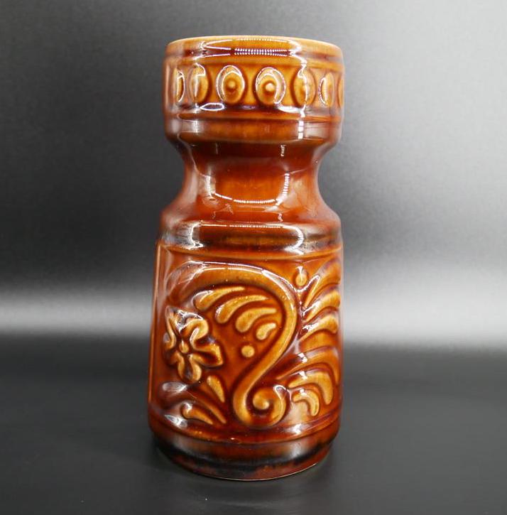 German pottery vase with rich brown glaze, raised floral scrollwork design, cream interior, marked G 122-18 on base