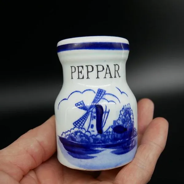 Hand-held pepper shaker displaying PEPPAR label and intricate blue maritime landscape with sailing vessel imagery