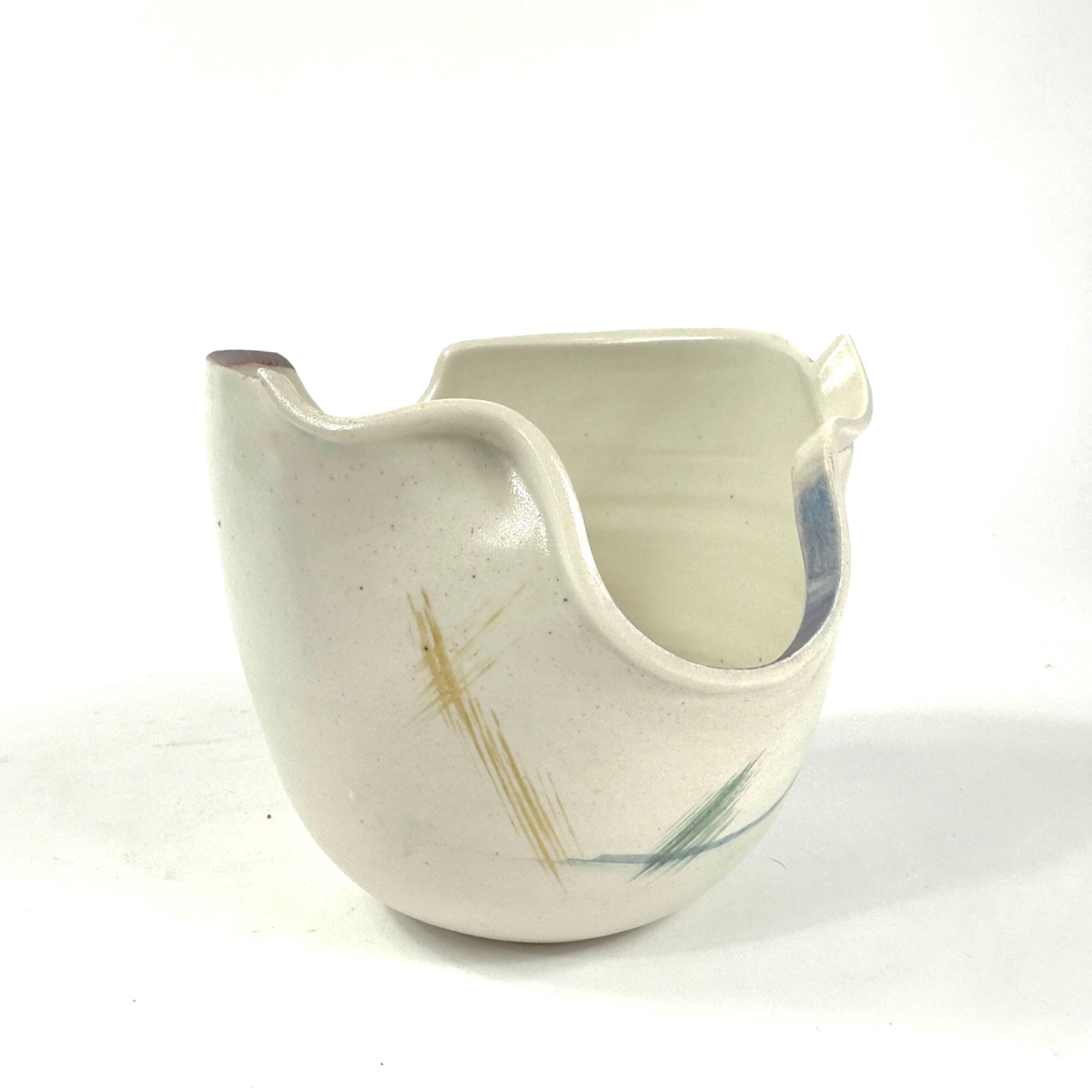 Hand-thrown studio pottery bowl signed J. Higgins 81, cream stoneware with abstract blue and golden brushstrokes, organic wav
