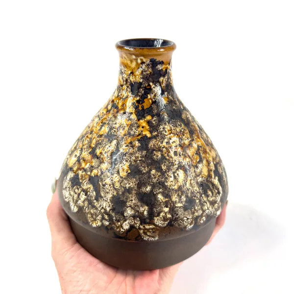 Hands supporting vase to display shoulder-to-base proportions with full glaze texture visible