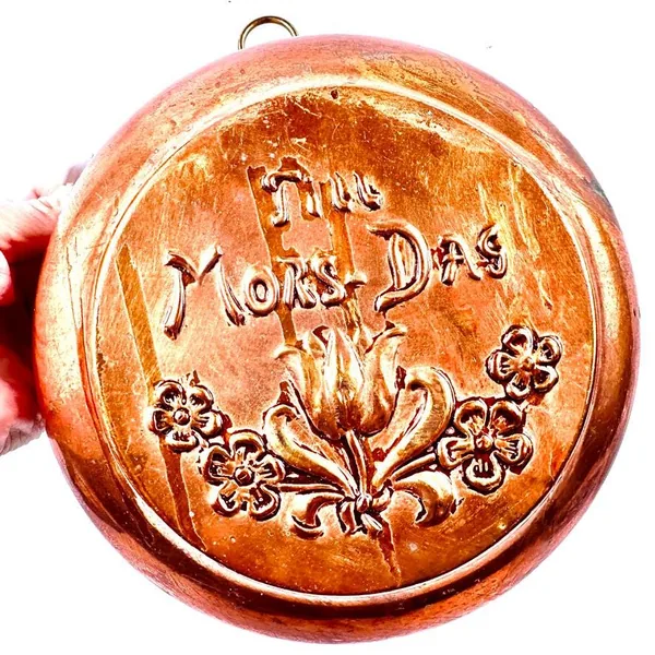 Held in hand, copper plate showcases embossed 'Til Mor-Dag' text with surrounding relief flowers and aged patina