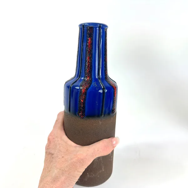 Held profile showing complete vase silhouette, neck-to-base proportions, glazed upper section, unglazed lower body, and overa