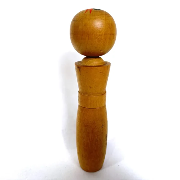 Kokeshi doll straight-on view, golden wood construction, simple elegant form with polished rounded head