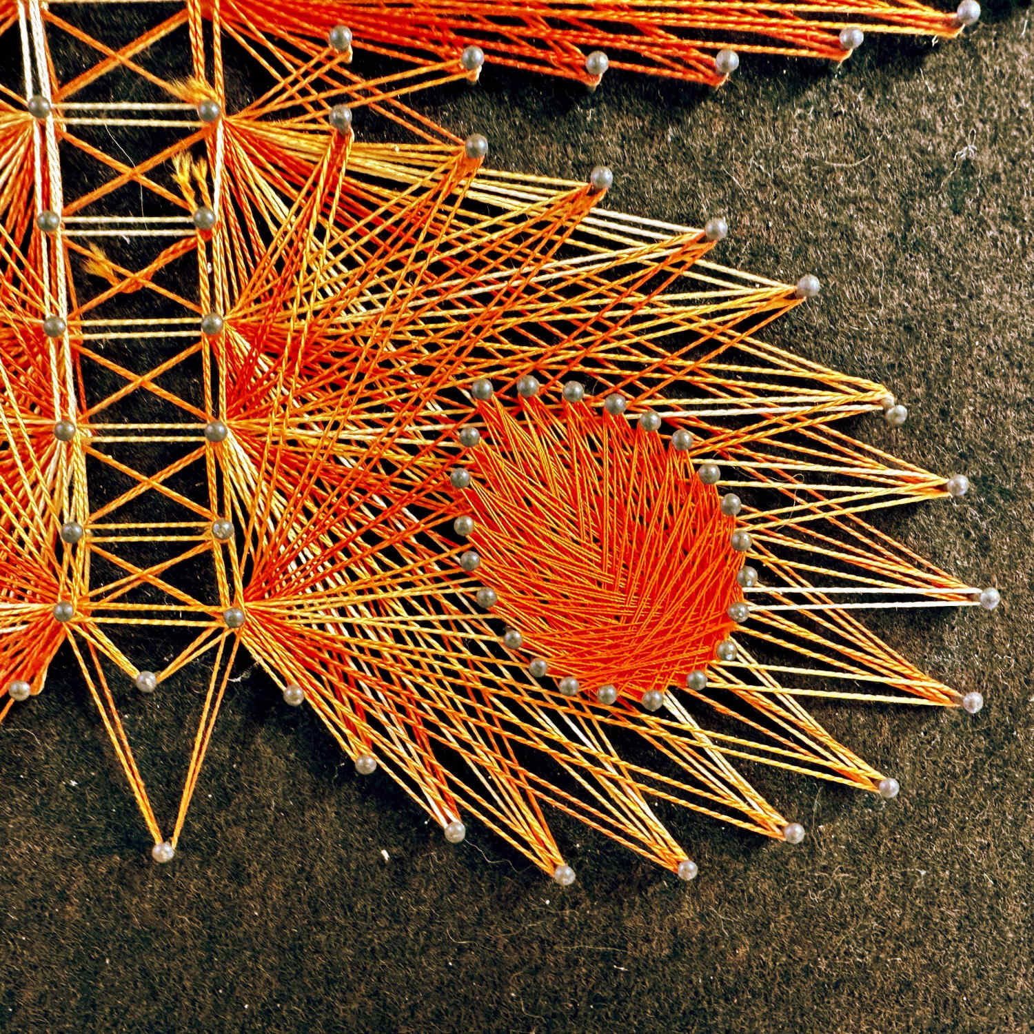 Lower butterfly wing close-up showing red thread wrapping and geometric circular motif detail