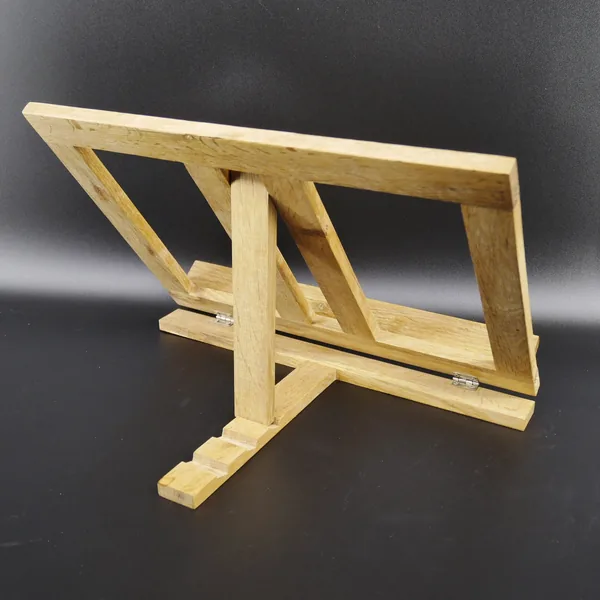 Natural pine book stand diagonal view, angled supports visible, wood grain texture highlighted, functional folding design evi