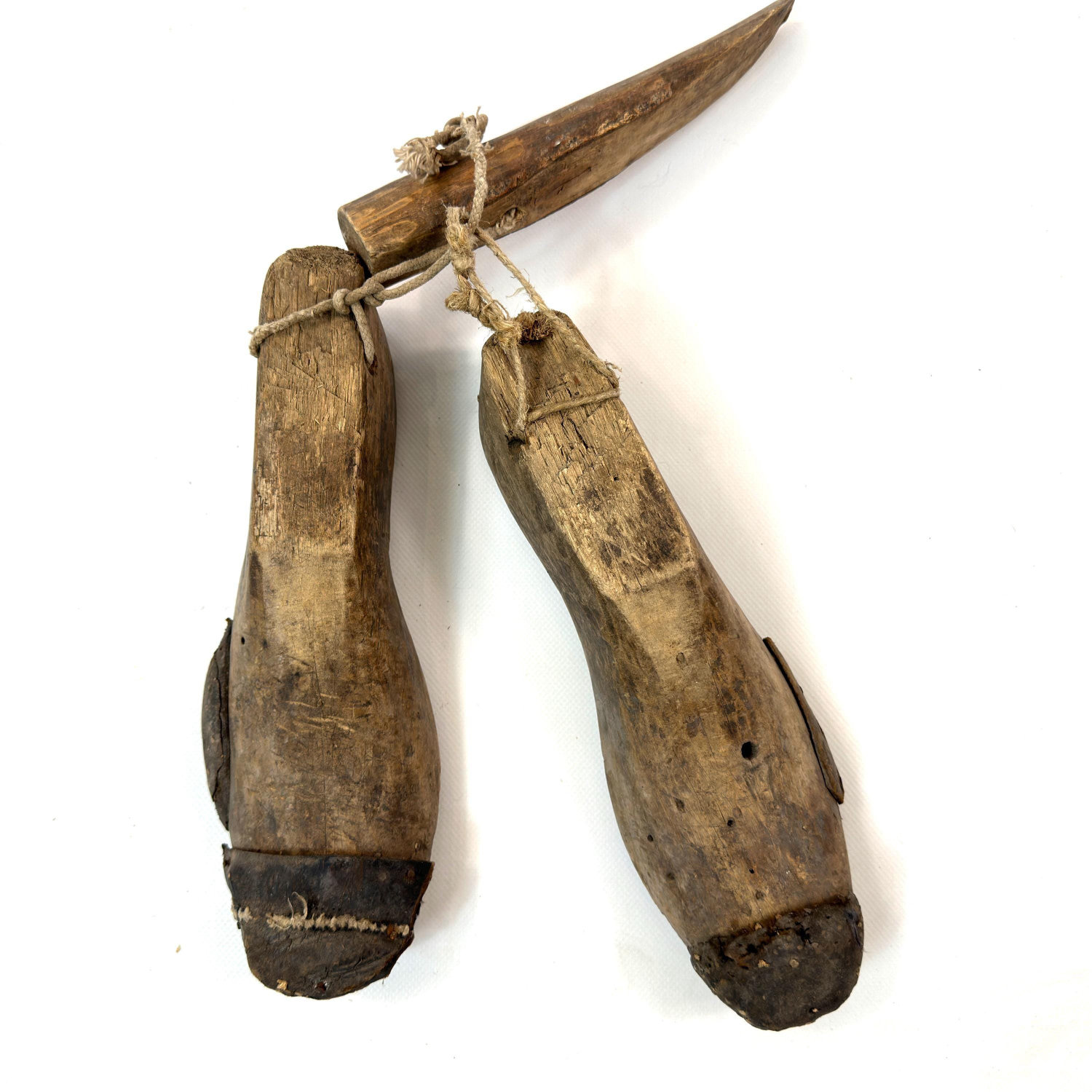 Pair of early 1900s European wooden shoe lasts with leather toe caps, connected by rustic cord, displayed from above
