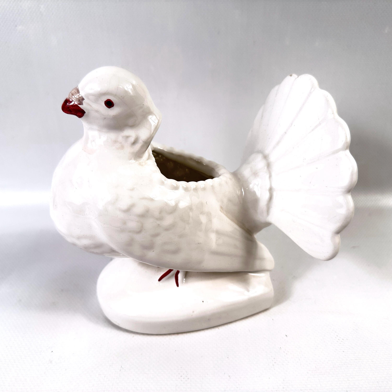 Pereiras Portuguese porcelain dove vase, white glazed ceramic bird with fanned tail and burgundy eye details, three-quarter v