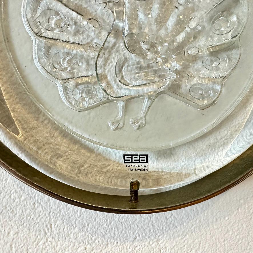 Reverse side of glass plaque showing SEA maker's mark impressed into the glass surface, flat overhead perspective