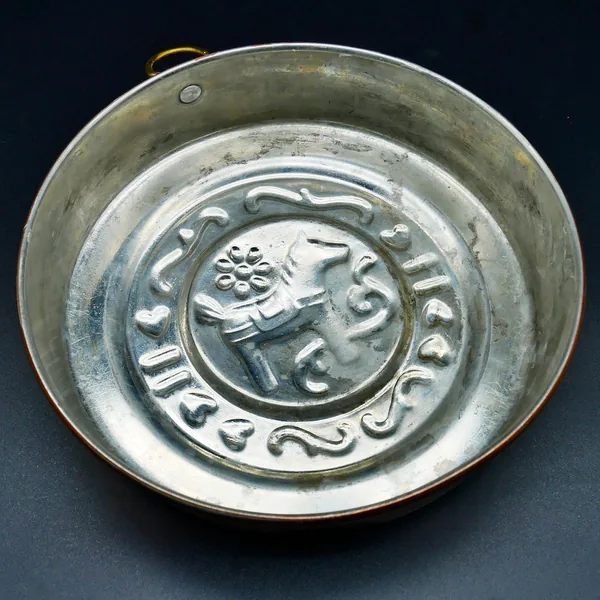 Reverse side of mold showing silvery tin lining and recessed center with age patina