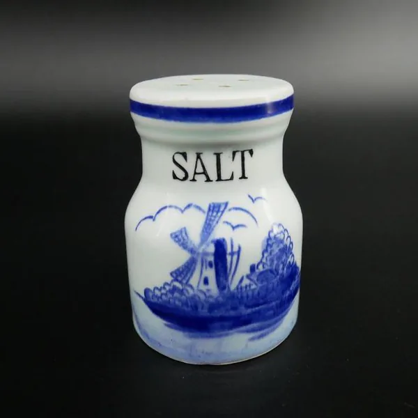 Salt shaker isolated showing full ceramic form with curved waist, blue trim band, and painted windmill landscape detail