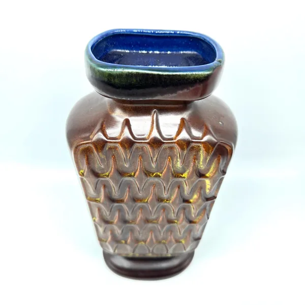 Scheurich pottery vase showing three-quarter front view with deep chevron texture, brown glaze, and contrasting cobalt-blue r