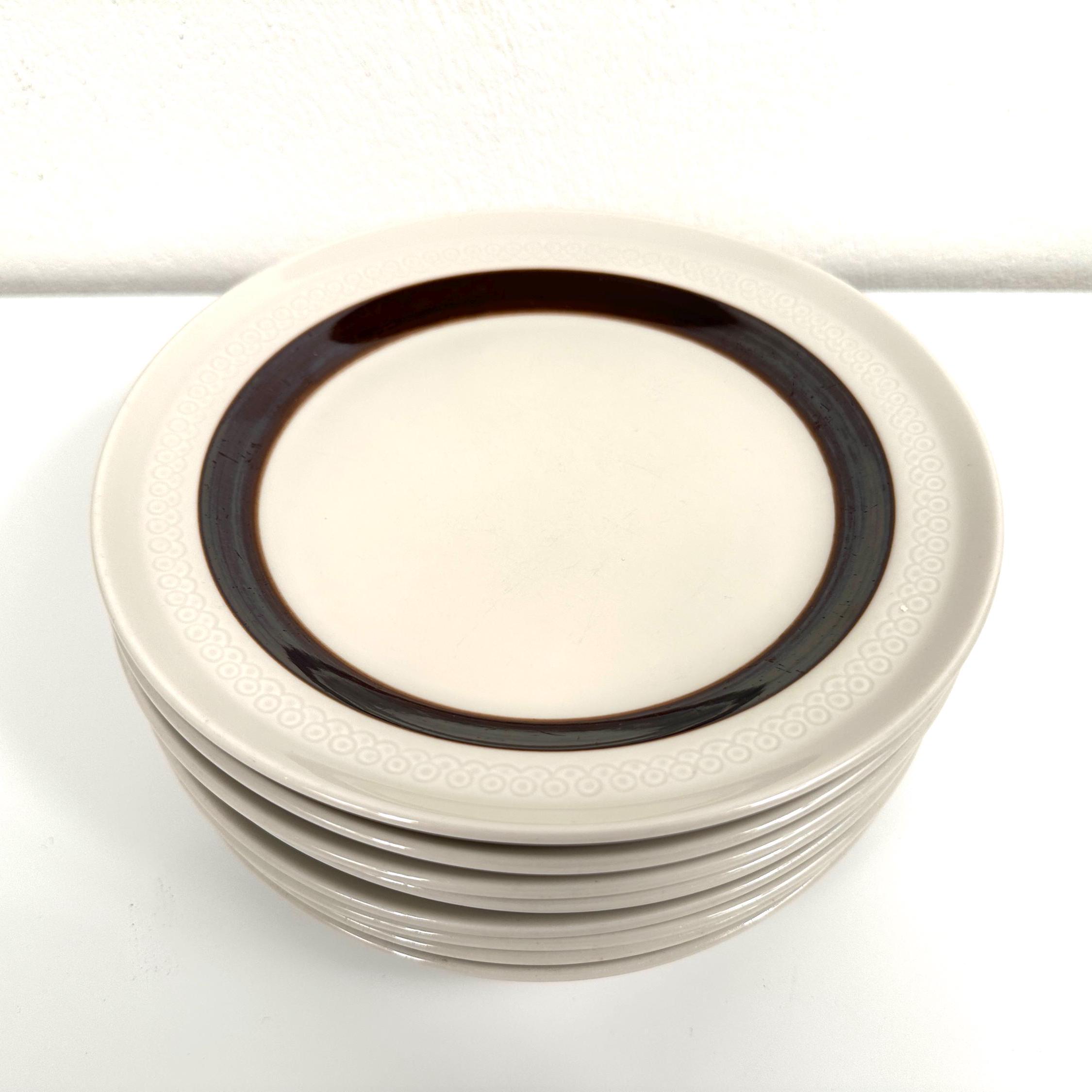 Stacked Rörstrand FORMA plates from side angle showing multiple charcoal bands and ceramic glaze depth
