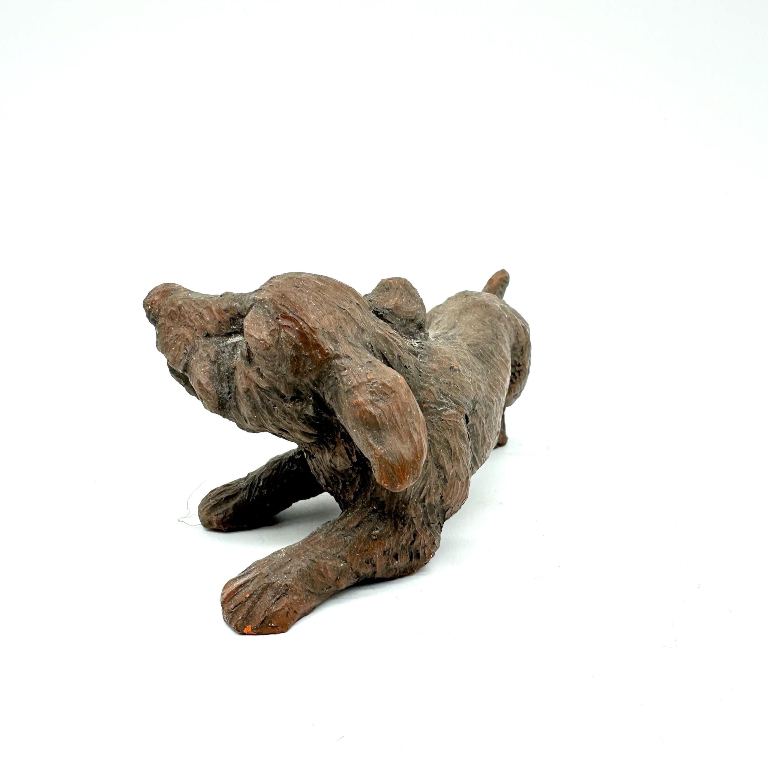 Studio ceramic dog from elevated rear angle, showing back body contours, tail position, and three-dimensional sculptural form
