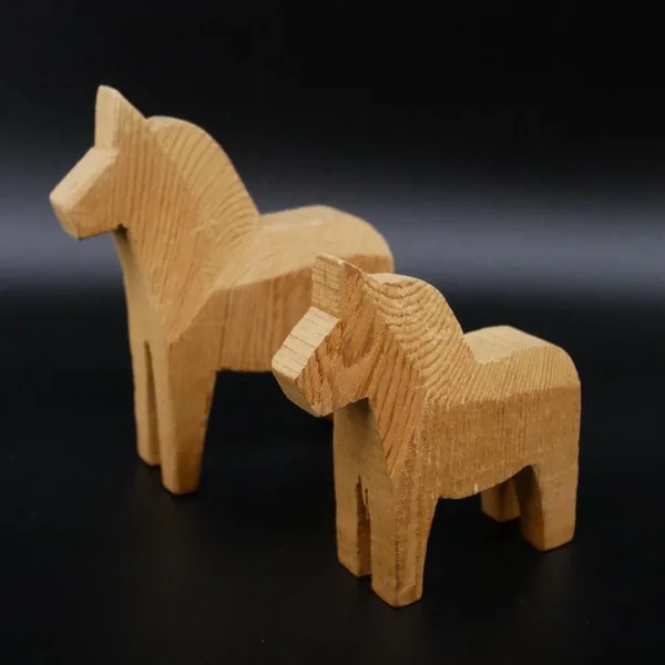Three-quarter angle of paired Dala horses emphasizing mane sculpting and body geometry from dynamic viewpoint