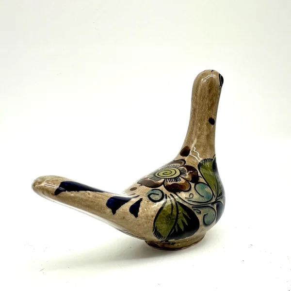 Tonalá ceramic bird viewed from above, showing decorative tail feathers with navy stripes and central floral body decoration