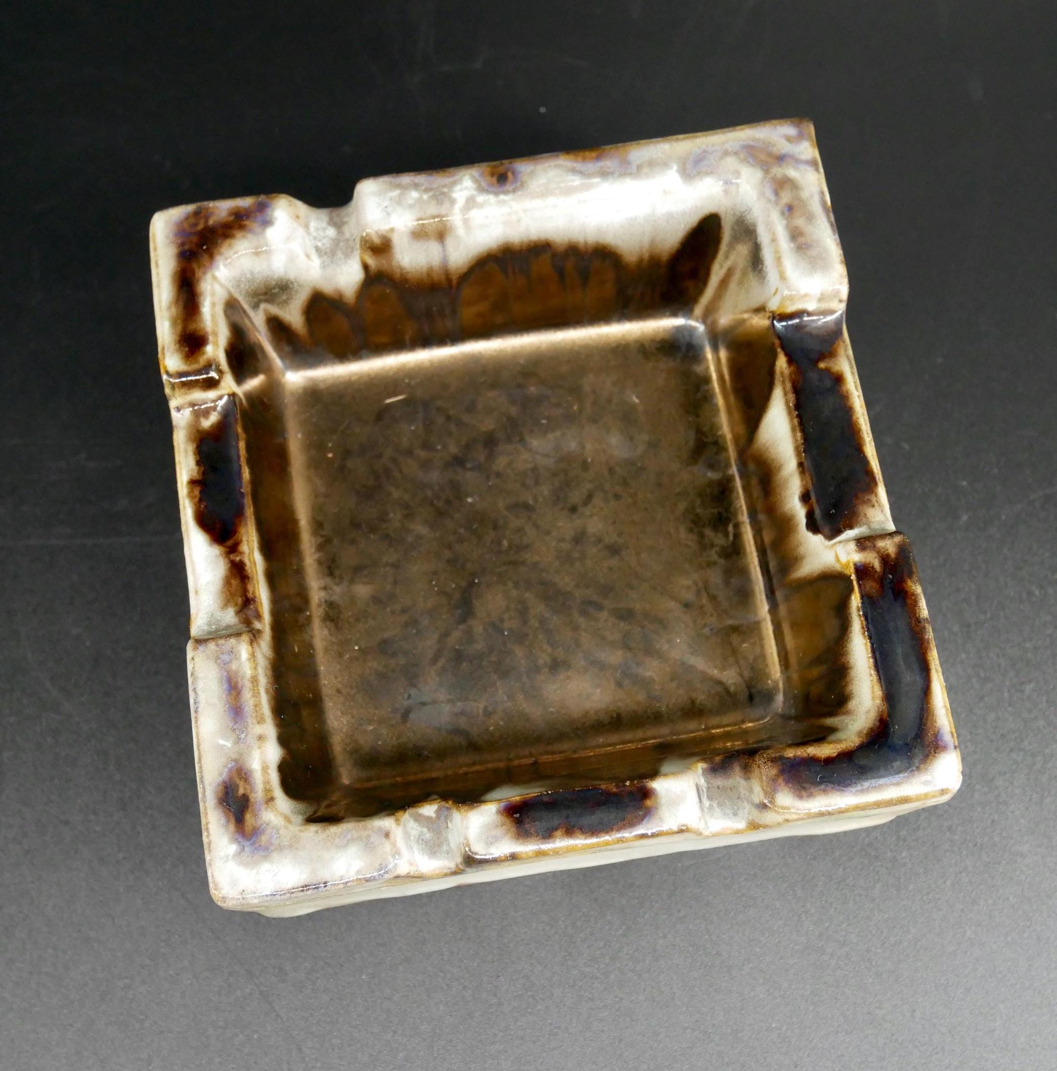 Top-down view of ceramic ashtray showing squared interior well, cream and brown glazed exterior, minimal wear