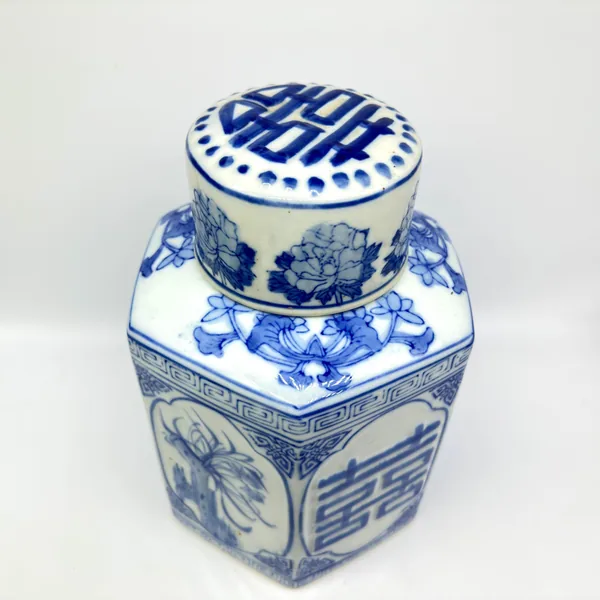 Top-down view of ginger jar lid showing Double Happiness geometric pattern in blue on white ceramic