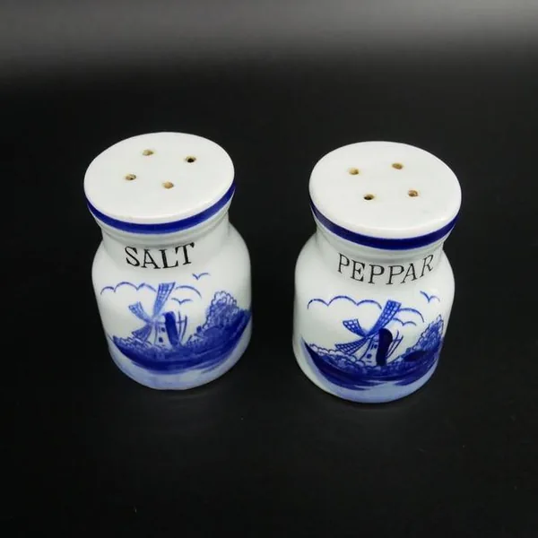 Top-down view showing perforated caps on both ceramic shakers with varying hole patterns for dispensing