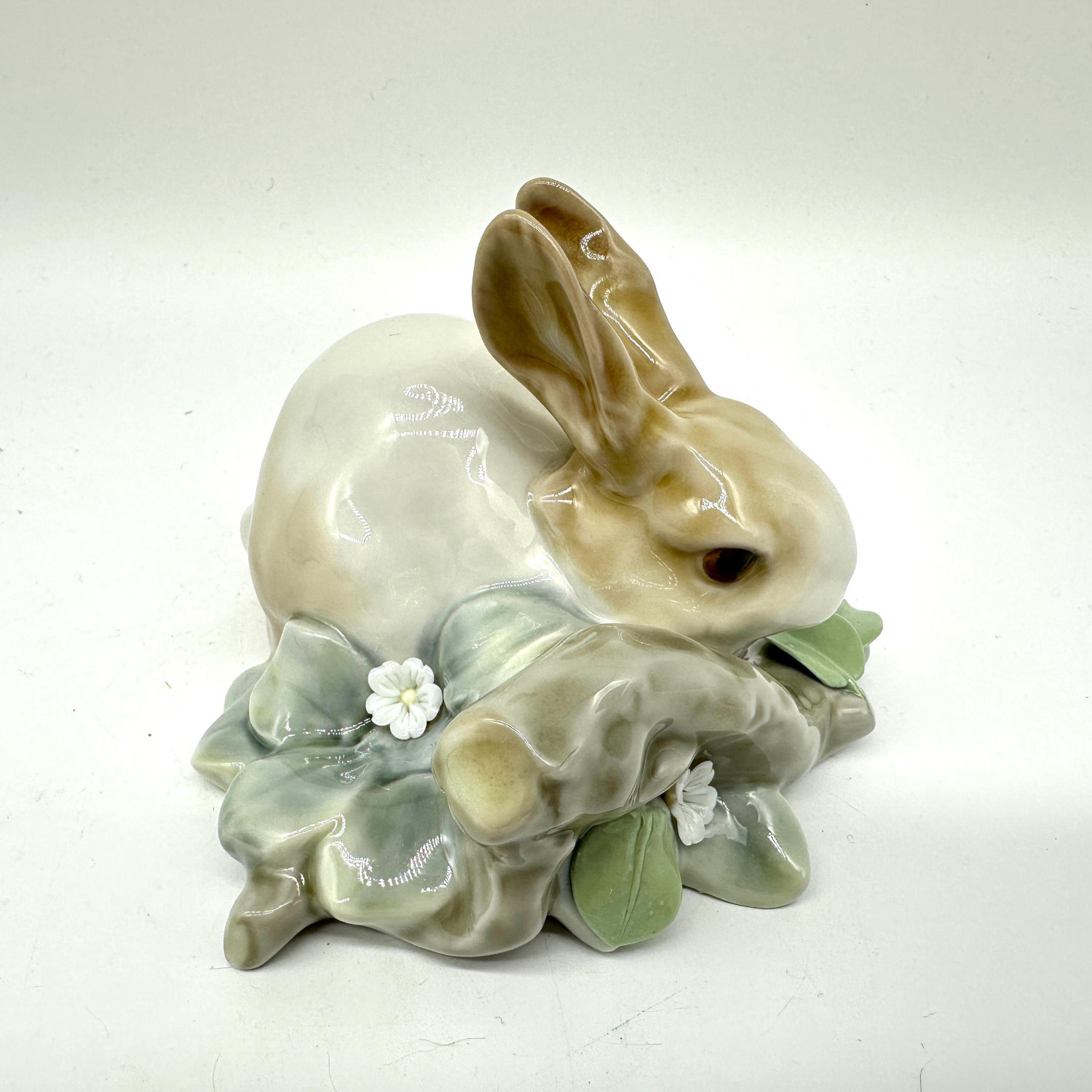 Underside of Lladro rabbit figurine showing manufacturer's mark and hand-painted blue Lladro mark on white glazed porcelain b