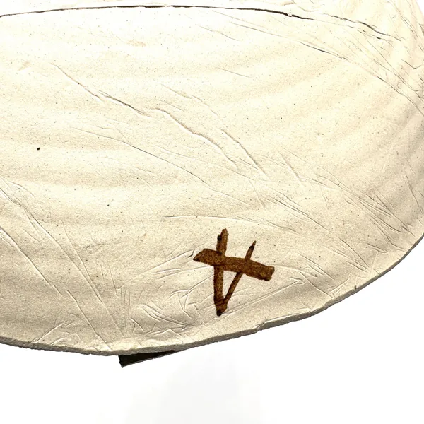 Underside of pottery bowl showing maker's mark, hand-thrown base with natural ceramic texture and visible craftsmanship signa