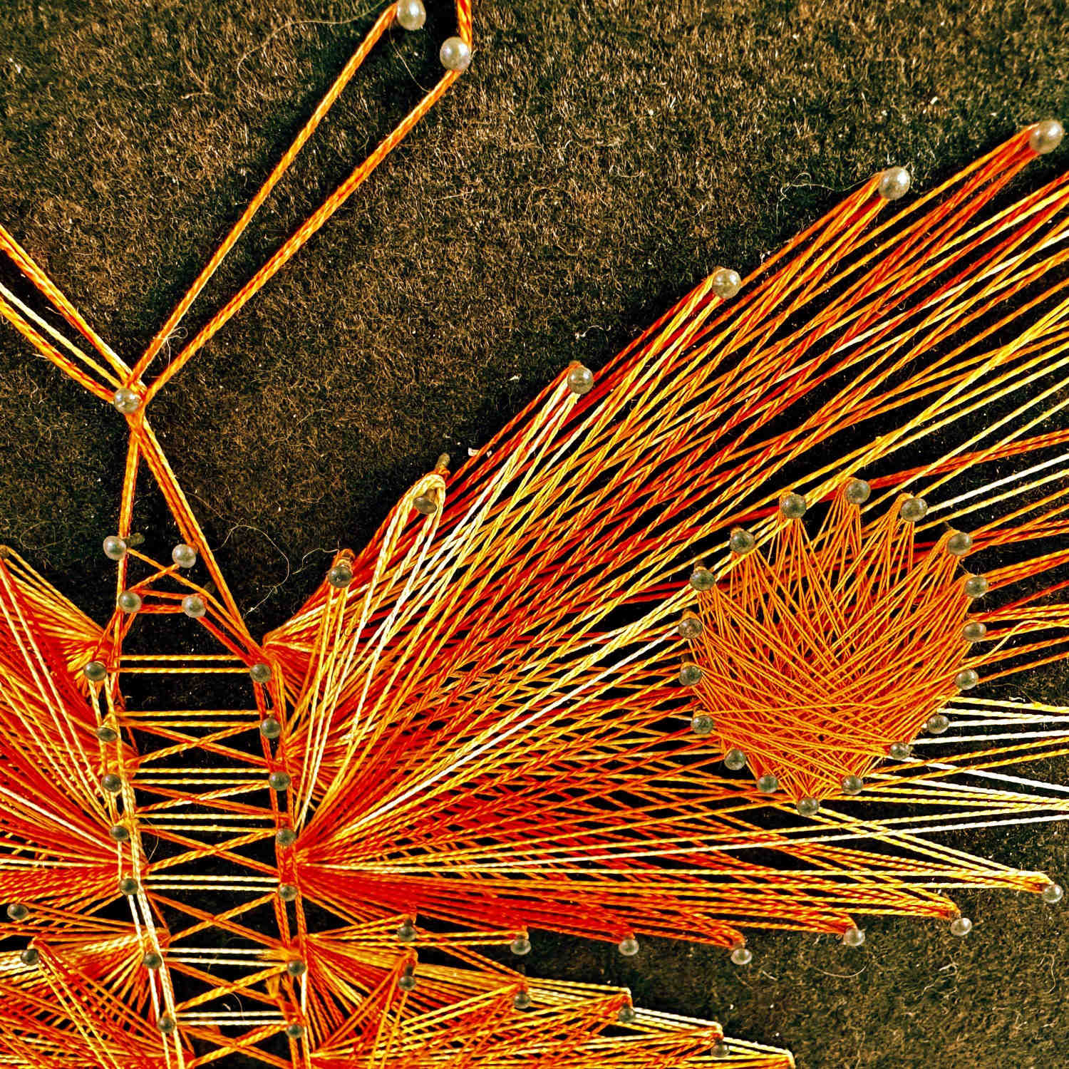 Upper left butterfly wing section showing orange and golden thread radiance pattern closeup