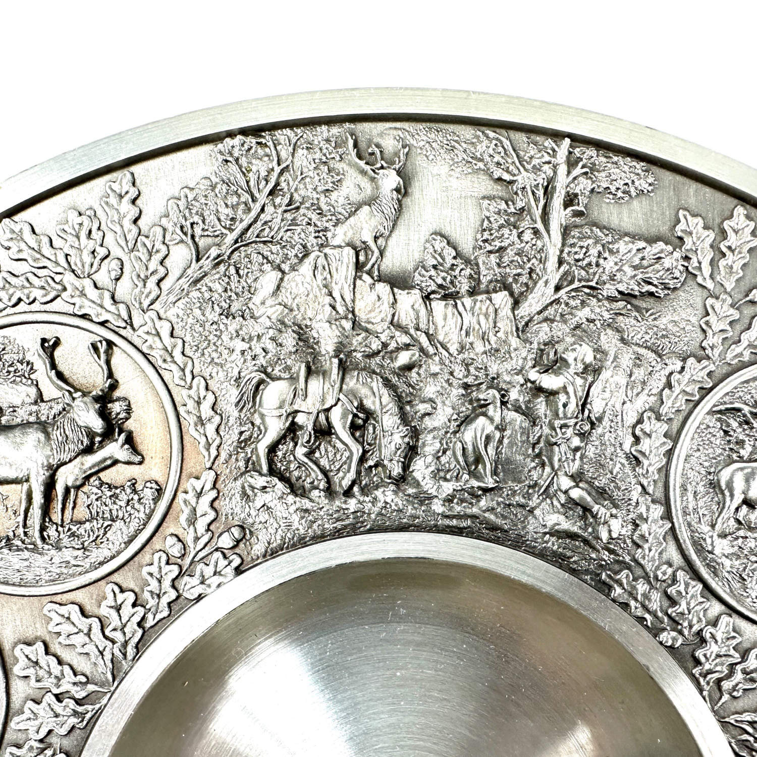 Upper section detail showing relief medallions with deer or stag figures and layered ornamental background landscape