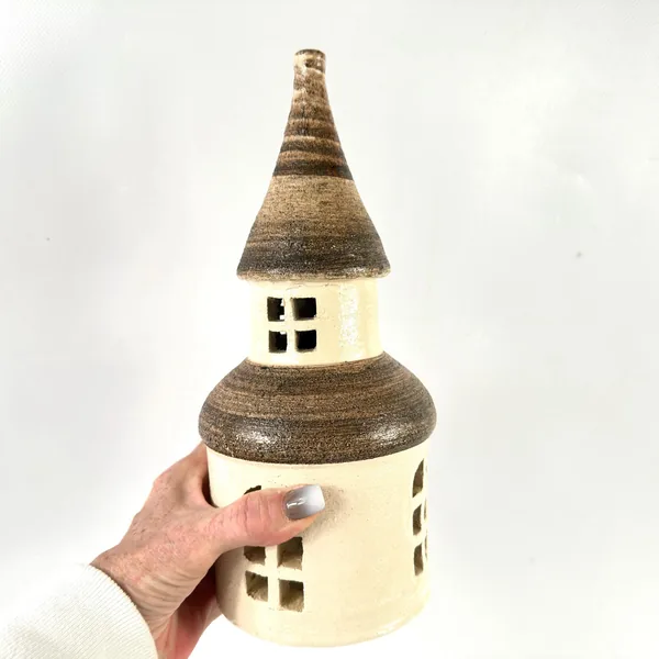 Vintage 1970s Brita Dals ceramic tower candle house with cream stoneware base, striped brown roof, and window cutouts, held i