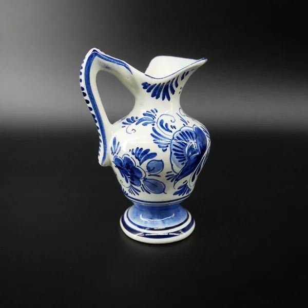 Vintage Delft ceramic jug angled view highlighting spout detail and painted botanical pattern in cobalt blue