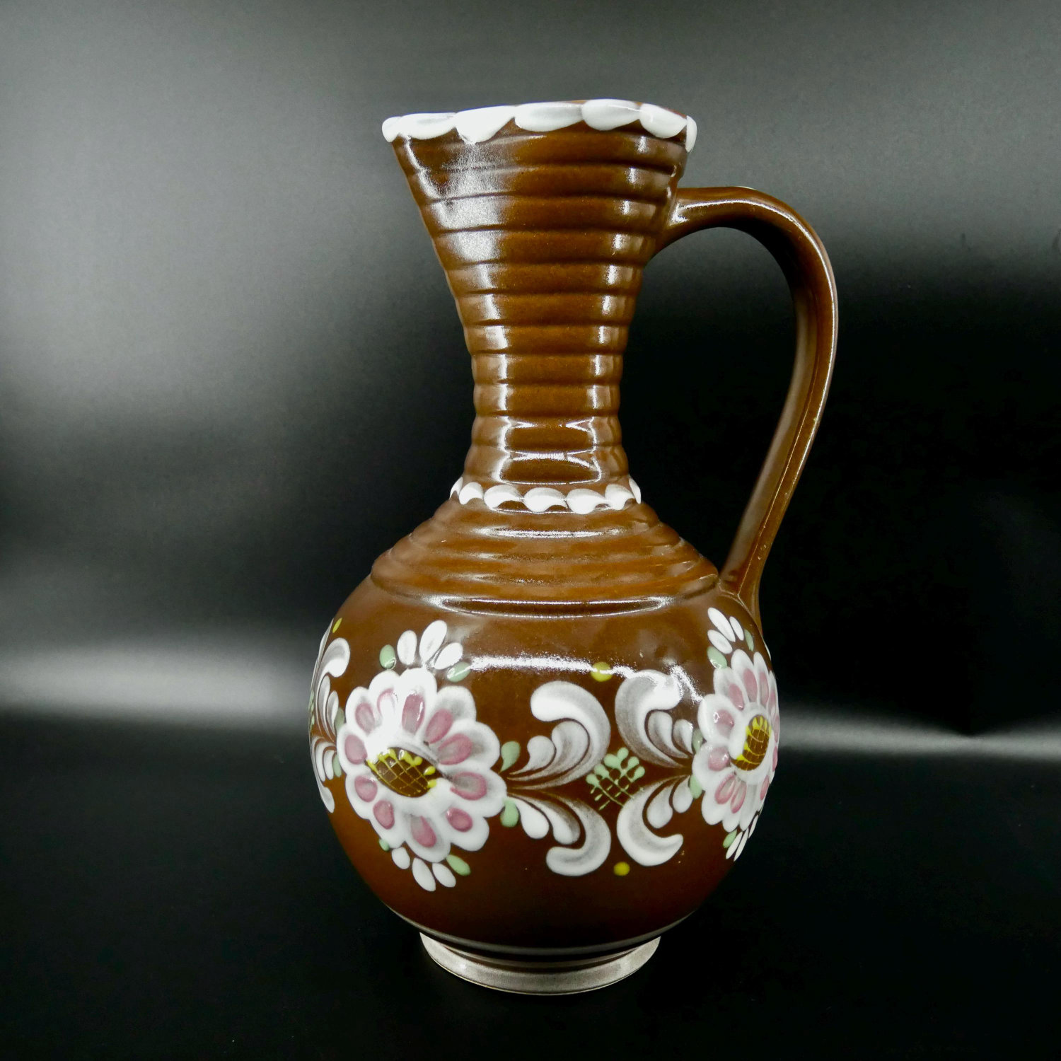 Vintage Gmundner Keramik Austrian ceramic pitcher with hand-painted chocolate brown glaze, white rim, and pink floral motif,