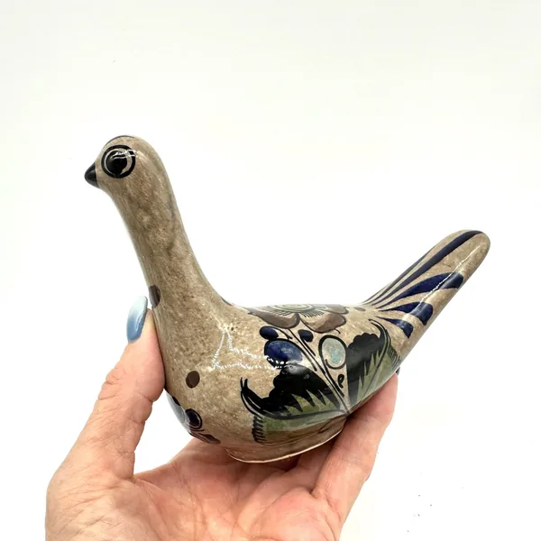 Vintage hand-painted Tonalá bird held in hands, showing compact scale and detailed ceramic glaze preservation