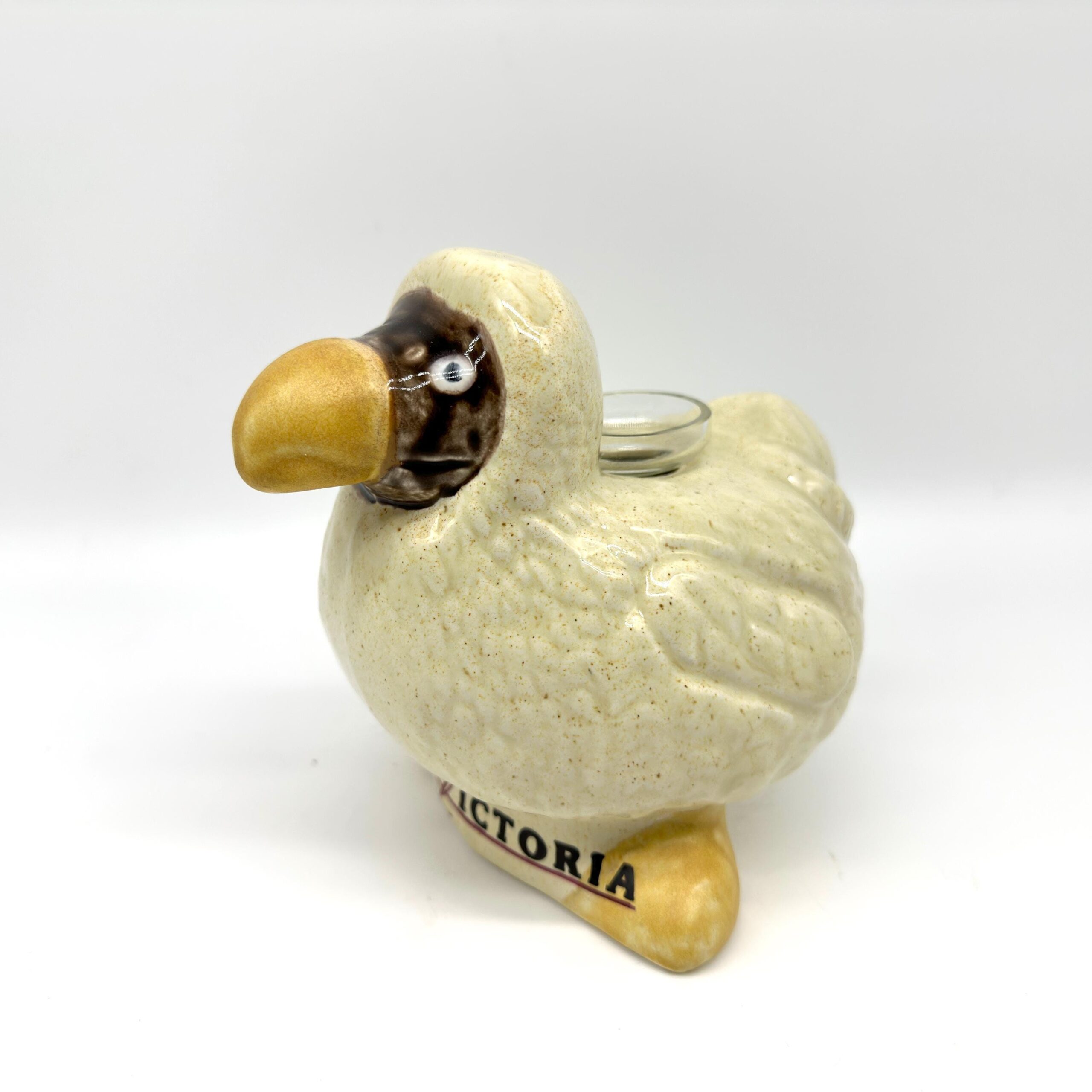 Vintage Le Victoria dodo bird ceramic figurine with cream speckled glaze, golden beak and feet, glass vase insert, front-faci