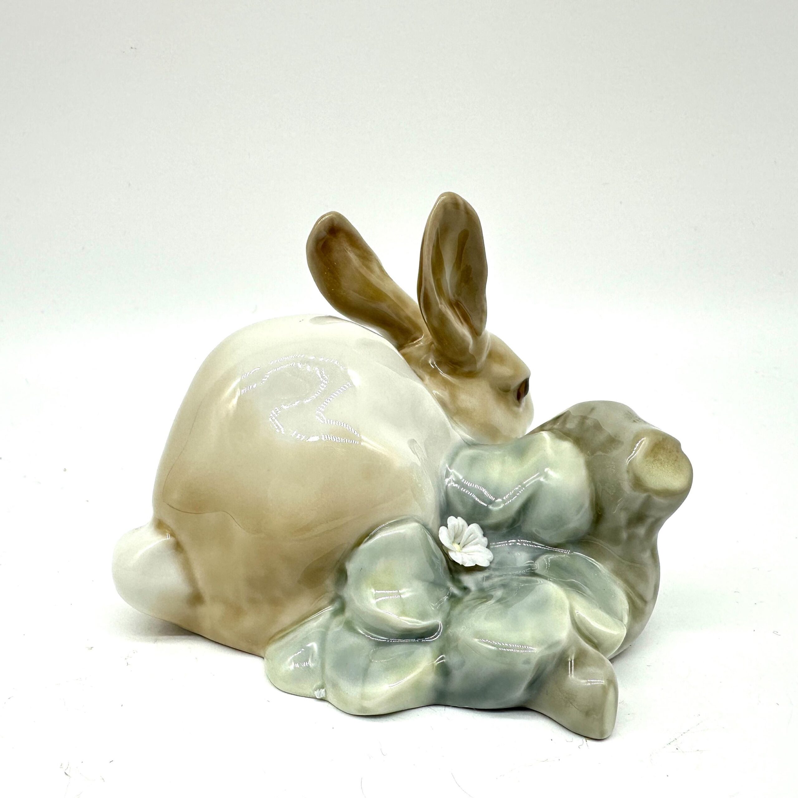 Vintage Lladro rabbit figurine viewed from right side angle displaying brown ears, pale porcelain finish, and sculpted green
