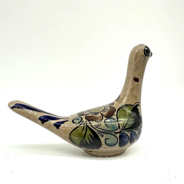 Vintage Mexican bird sculpture three-quarter angle, emphasizing glazed surface texture and hand-painted botanical composition
