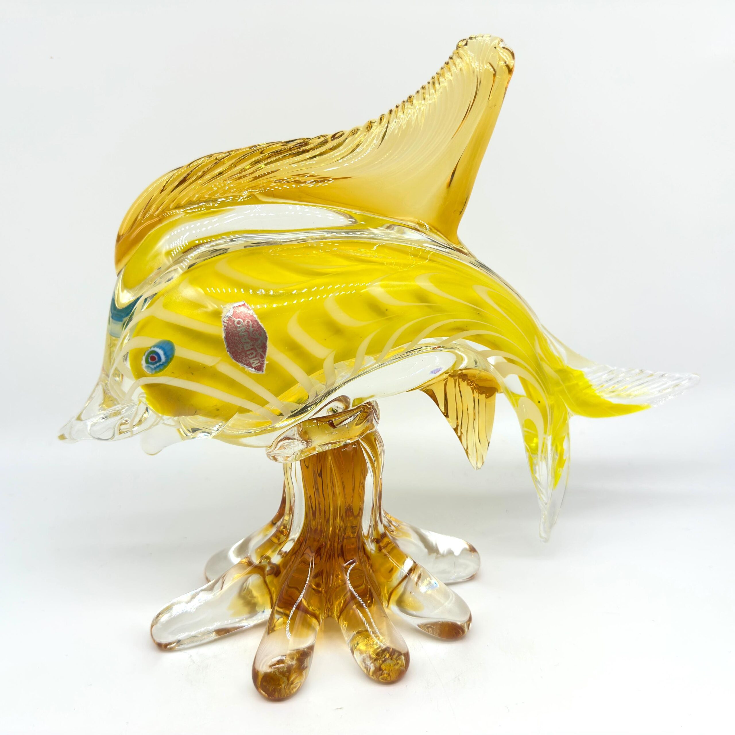 Vintage Murano art glass fish sculpture in golden yellow with white trails, millefiori eyes, and sculptural amber glass base