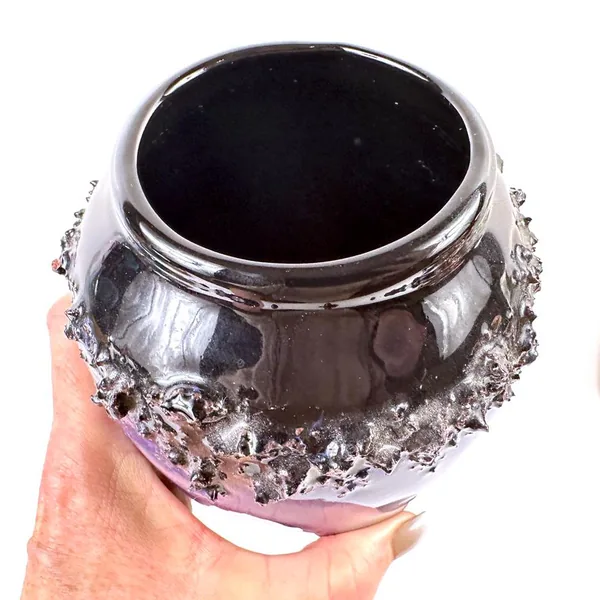 Vintage pottery vase in hand, angled view showing full volcanic band detail and cobalt blue depth