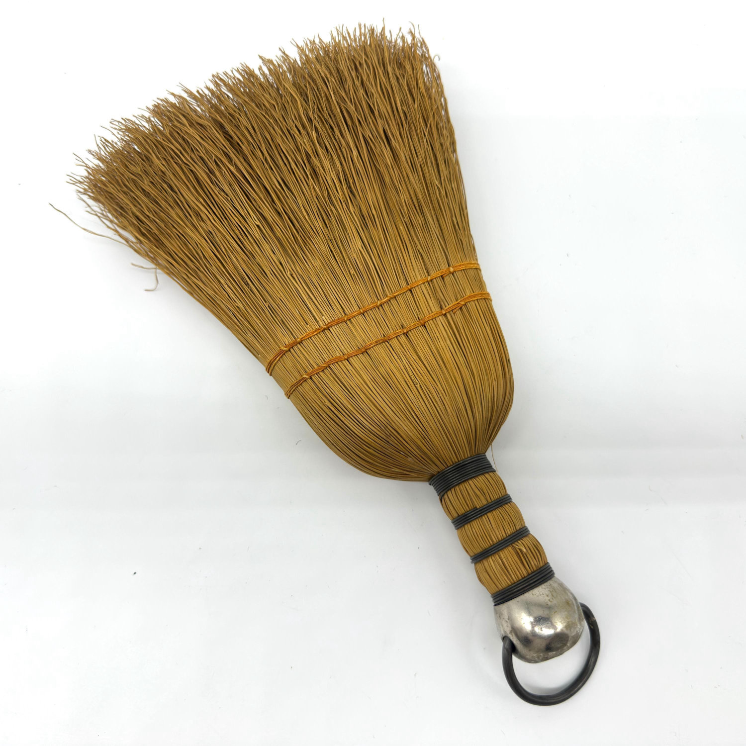 Vintage Scandinavian straw table brush with natural bound bristles, wooden banded handle, metal cap and hanging ring, angled