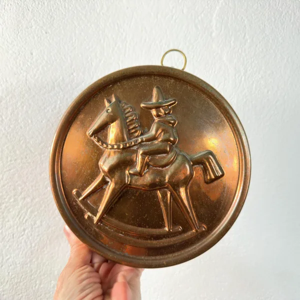 Vintage Swedish copper jelly mold with tin lining, featuring embossed folk art design of rider on rocking horse, complete wit
