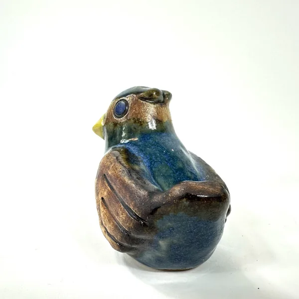 Vintage Willy Fischer pottery bird viewed from rear quarter, showing rich brown-gold glaze on tail feathers and curved body