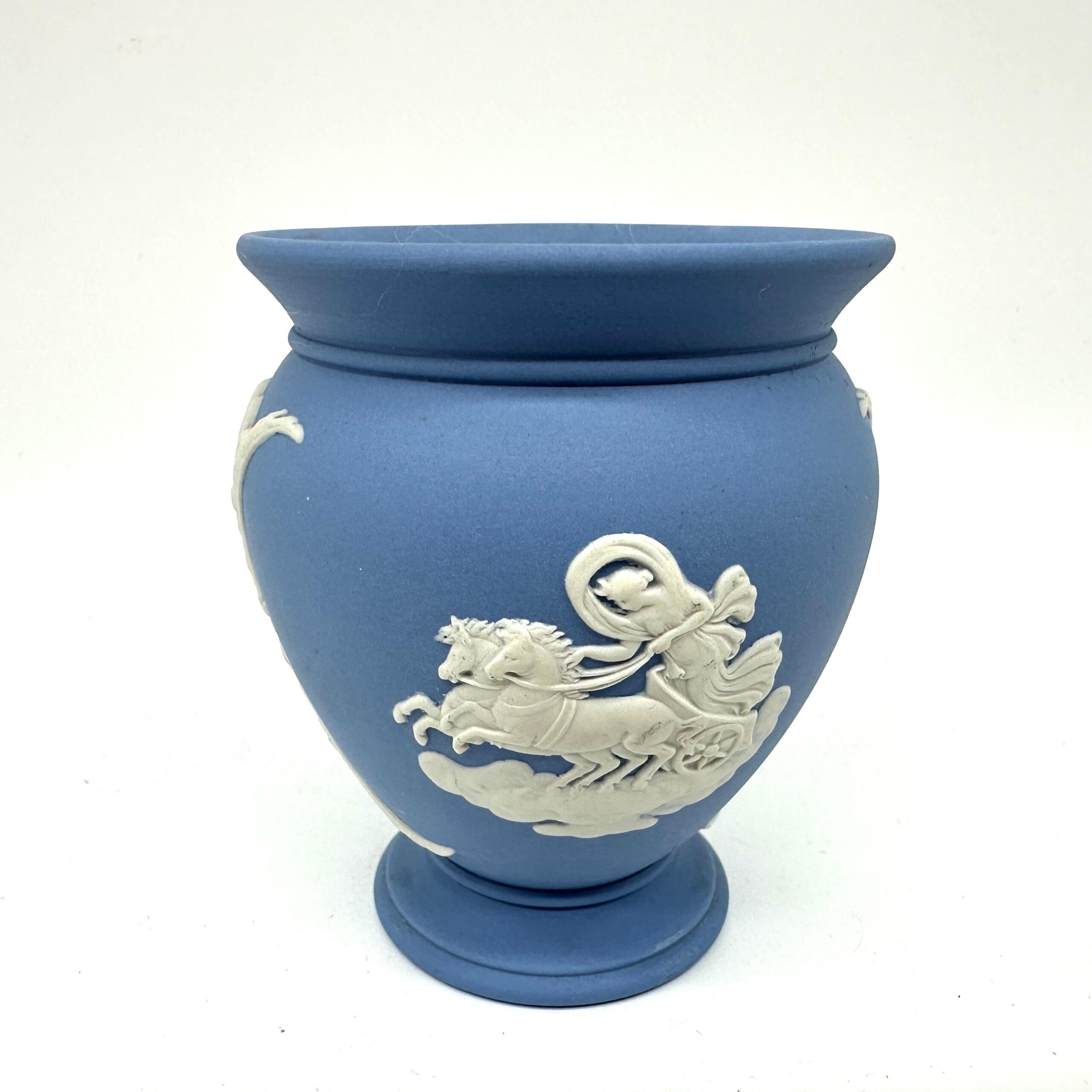 Wedgwood blue jasperware vase with white classical relief depicting winged chariot scene, pedestal base, front view