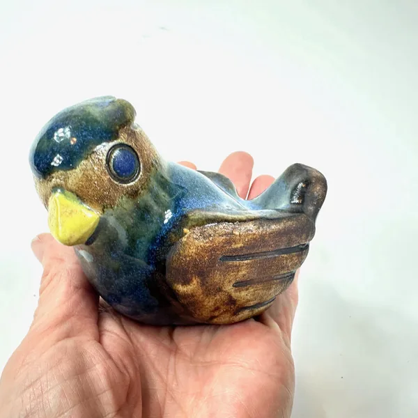 Willy Fischer bird held in hand, scale perspective showing 10cm length, detailed glaze surfaces and sculptural form clearly v