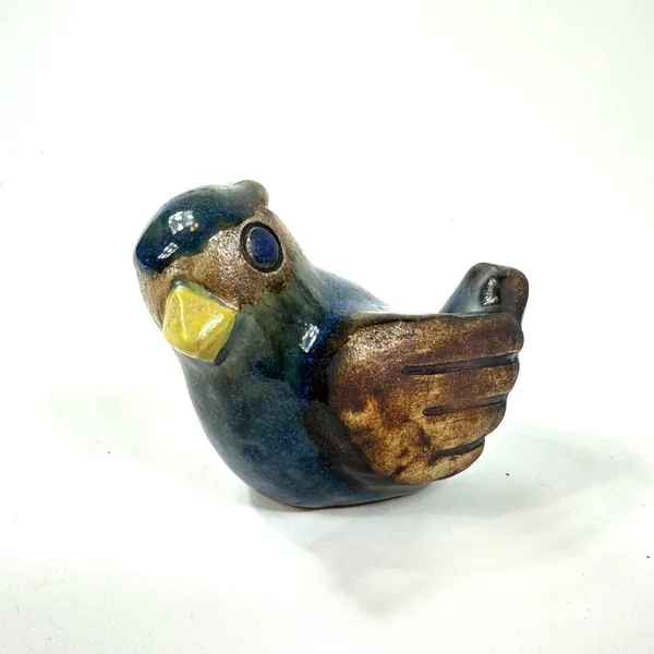 Willy Fischer stoneware bird figurine centered view, showing balanced form with cobalt dominant color and earth-tone accents