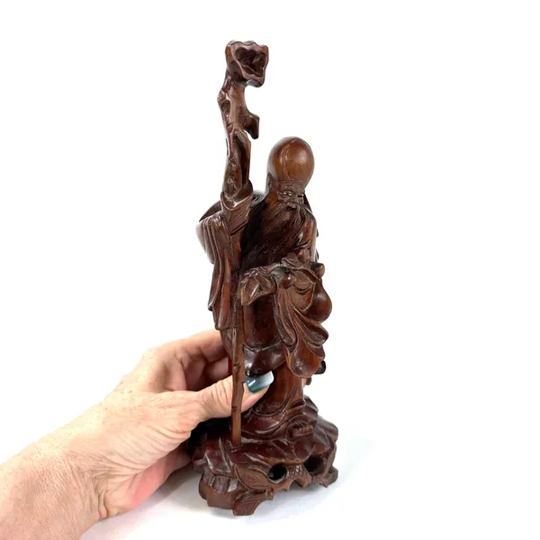 Wooden immortal figure scale photo held in hand, complete sculpture view, hand-carved proportions, vintage wood piece