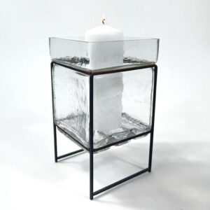 Mid-century Scandinavian candleholder with clear textured glass cube on black iron frame, three-quarter view showing sculptur