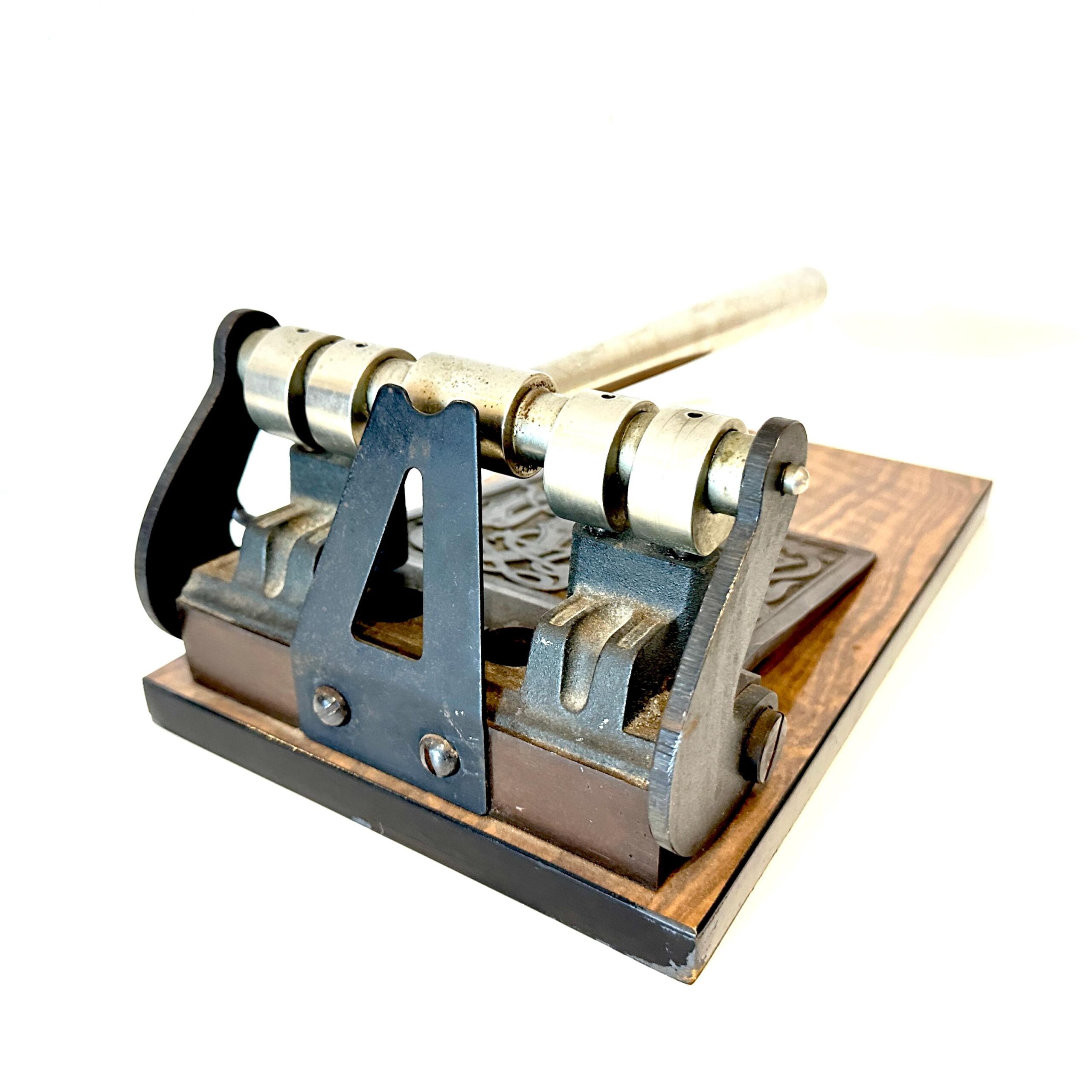 Three-quarter angle showing lever arm mechanism, cream and black components, and wooden mounting base together